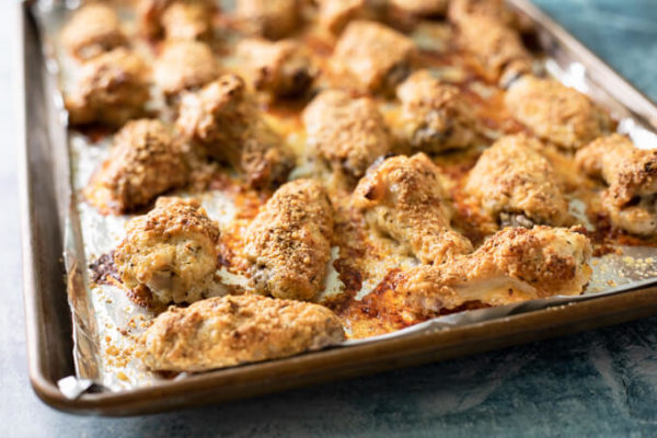 Crispy baked garlic parmesan chicken wings on a foil lined pan.