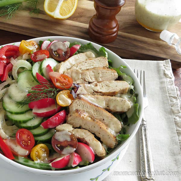 Grilled chicken salad with vegetables and dressing in a bowl with napkin