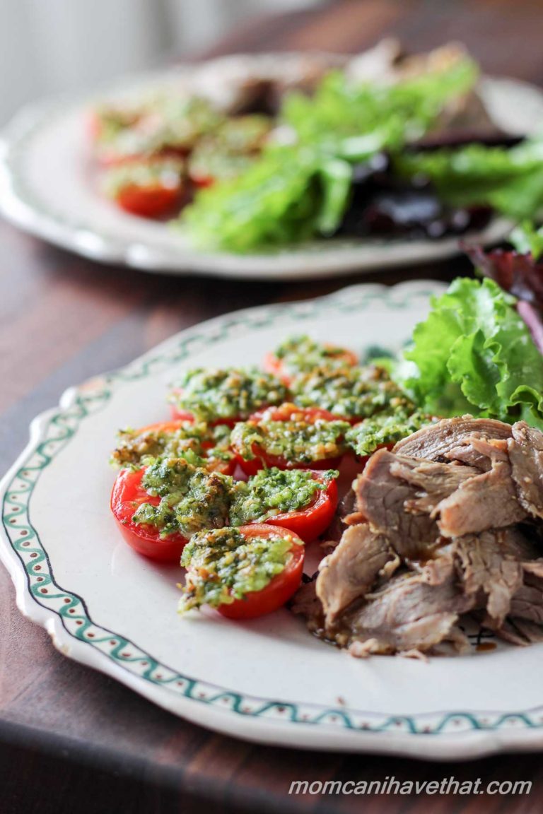 Baked Parmesan tomatoes on a plate with roast beef and salad.