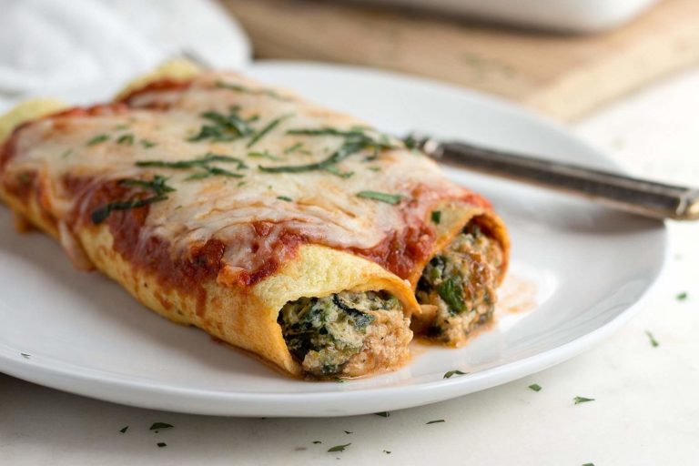 Low carb spinach manicotti on a white plate.