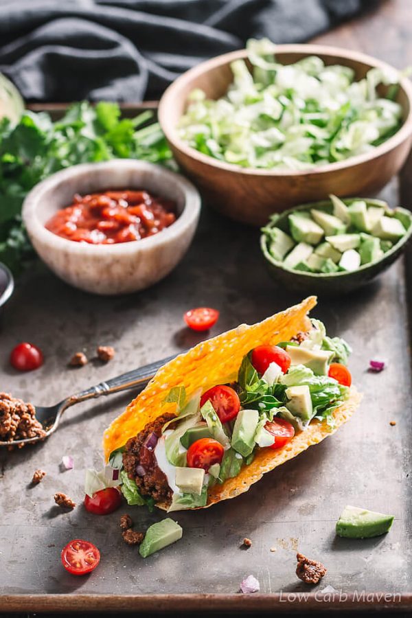 Ground beef taco on a pan with avocado, salsa and shredded lettuce.