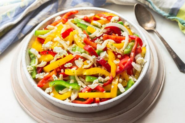 Colorful bell pepper salad with onions and feta.