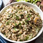 Ground beef stroganoff with mushrooms over cabbage noodles topped with parsley.
