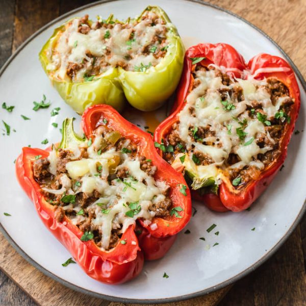 Sloppy Joe stuffed bell peppers top with cheese on a plate.