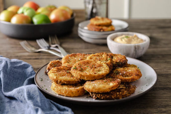 Crispy fried green tomatoes on a plate with dipping sauce