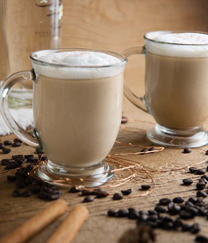 Low Carb Russian Coffee on wood with coffee beans, a white blanket, and cinnamon sticks and vodka