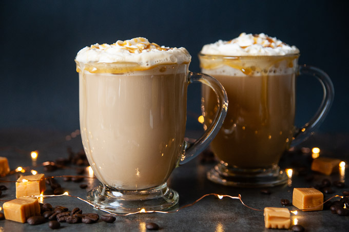 Sugar free coffee drink with whipped cream and caramel drizzle in a glass mug with handle
