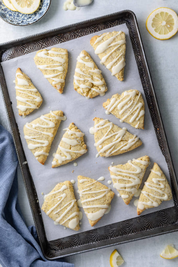 Low Carb Lemon Poppy Seed Scones with lemon glaze on parchment lined sheet pan