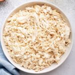 How to make shredded chicken: shredded chicken in white bowl with blue napkin