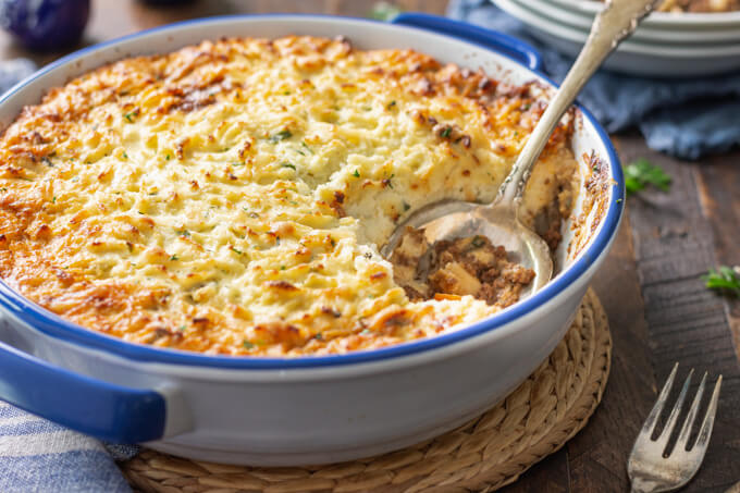 keto shepherd's pie with browned cheesy cauliflower topping with spoon.